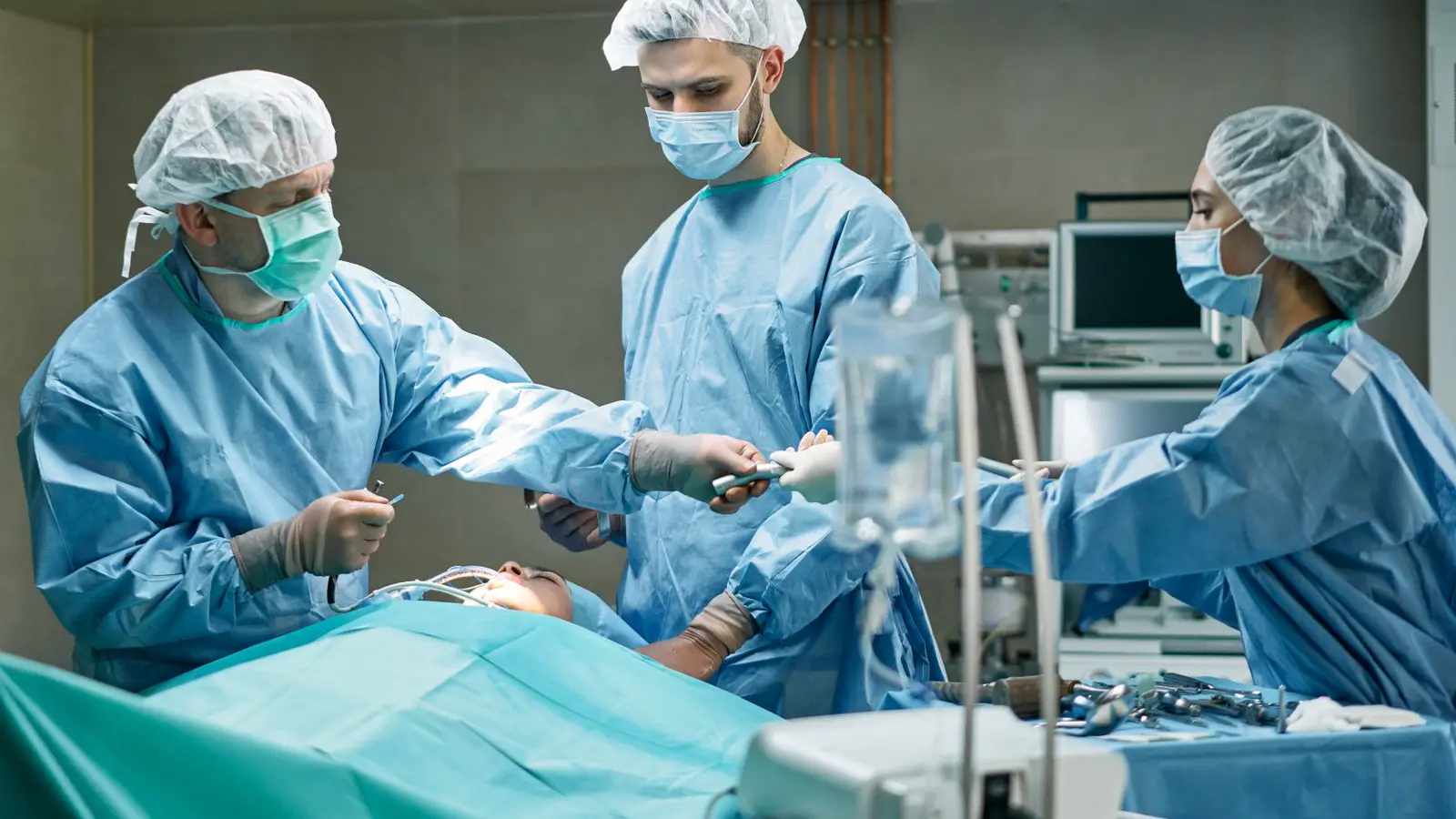 Equipe cirúrgica com cirurgião e anestesista durante procedimento em sala de cirurgia