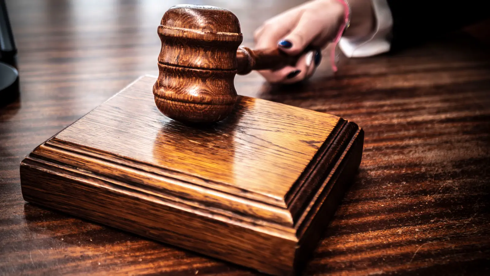 Martelo de juiz sobre mesa de madeira, representando a interdição cautelar com que o CRM pode suspender o médico antes do julgamento do processo ético