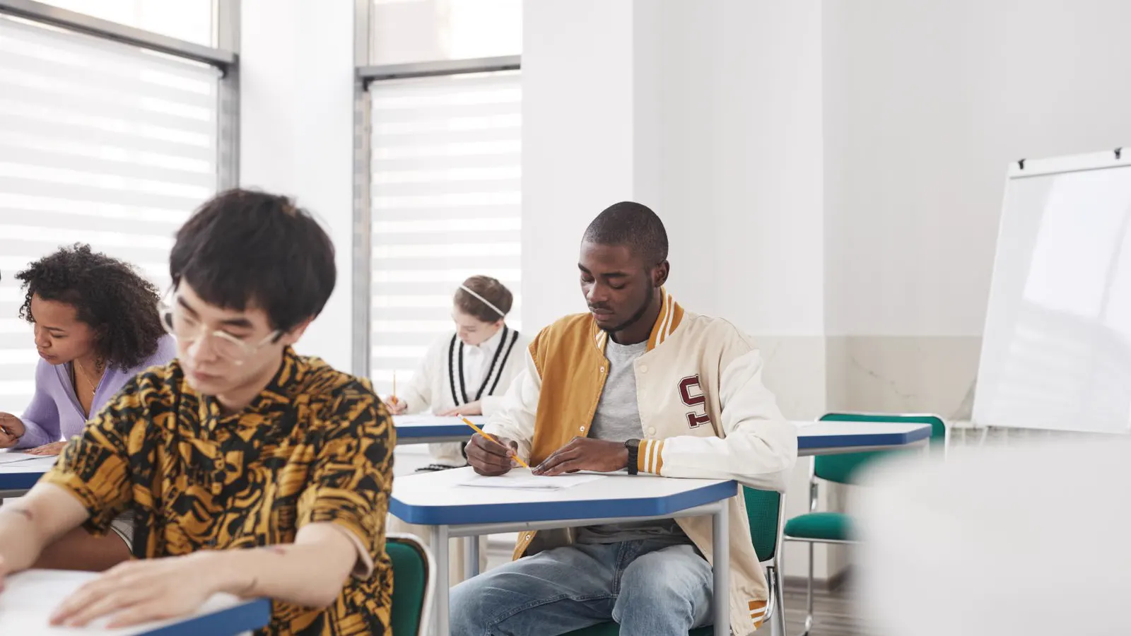 Estudantes de Medicina fazendo prova em sala de aula, ilustrando o Enamed obrigatório para o registro no CRM