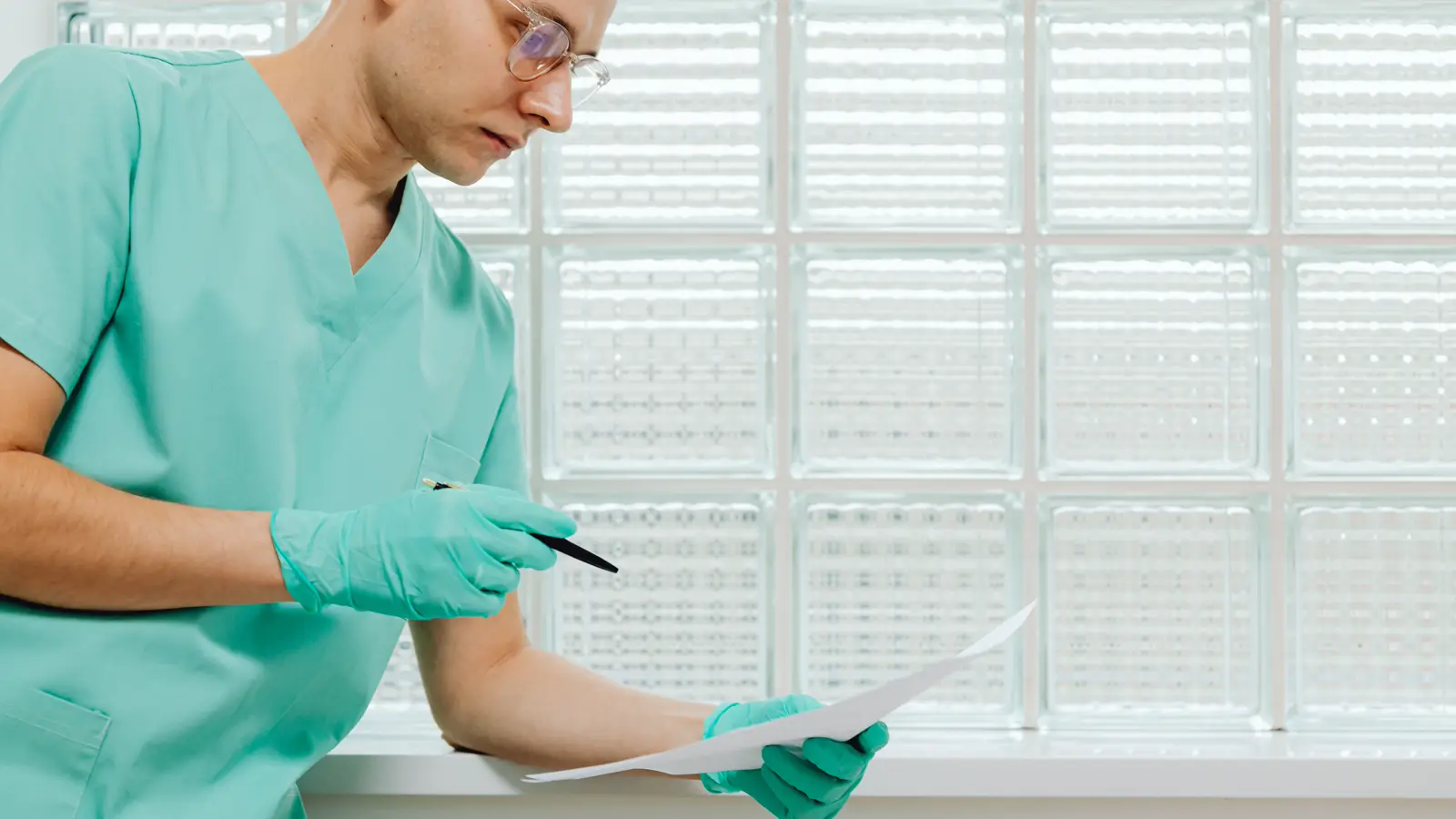 Médico de jaleco analisando documento em consultório, representando o pedido de auxílio-doença do INSS pelo contribuinte individual