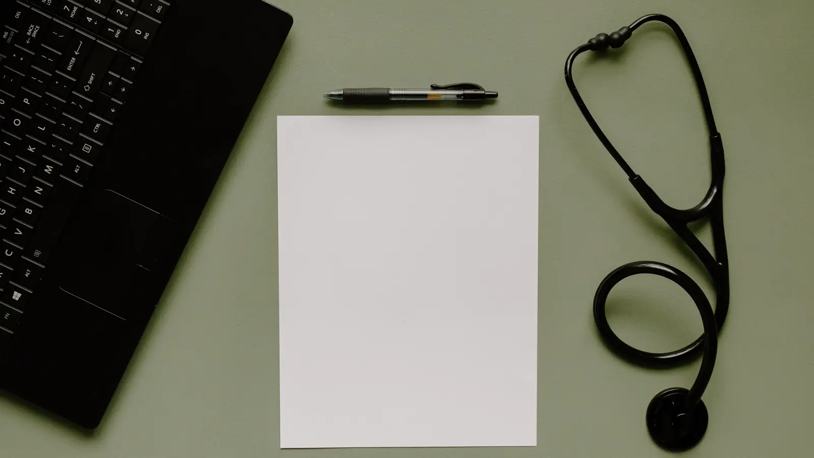 Estetoscópio, folha em branco, caneta e notebook organizados sobre mesa, representando a burocracia da abertura de CNPJ pelo médico