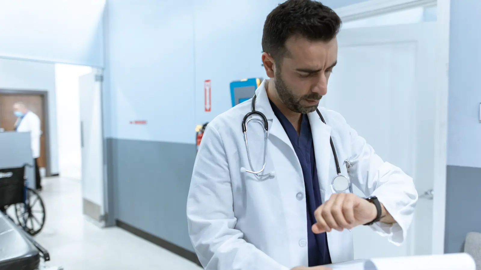 Médico residente de jaleco branco no corredor do hospital durante plantão