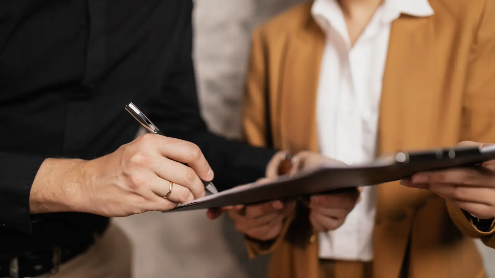 Duas pessoas assinando documento de contrato em ambiente de escritório
