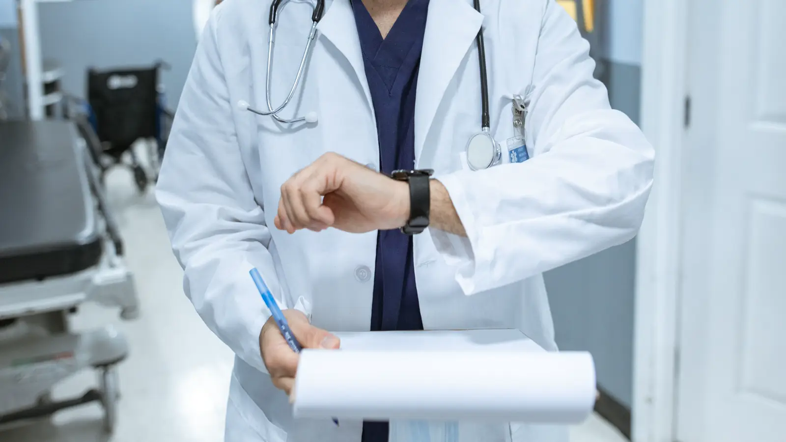 Médica residente de jaleco revisando documentos e extrato previdenciário em corredor de hospital, representando a contagem do tempo de residência médica para o INSS